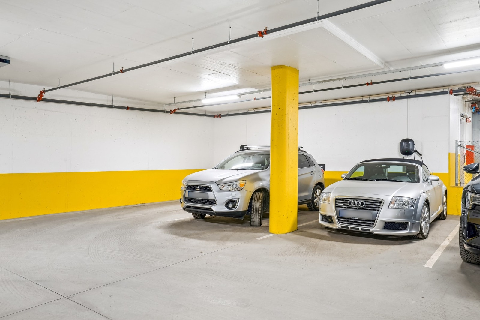 Parkeringsplass med elbillader. Det er også en bod til, som er tilgjengelig via garasjeanlegget. Galleribilde