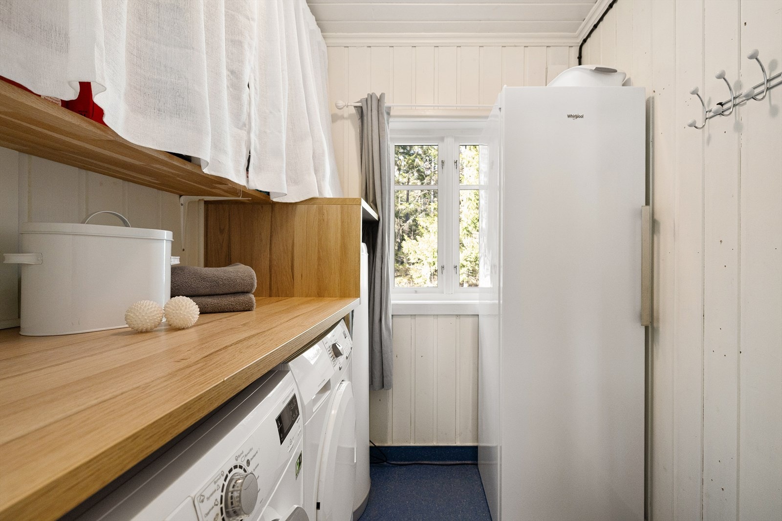 Innenfor kjøkkenet er en praktisk bod hvor det er plasser vaskemaskin, tørketrommel og ekstra kjøl/fryseskap. Galleribilde