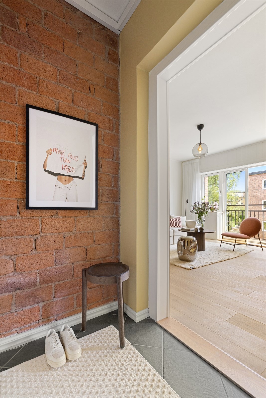 Entré med flislagt gulv, malte veggflater og en brytningsvegg i teglstein Galleribilde