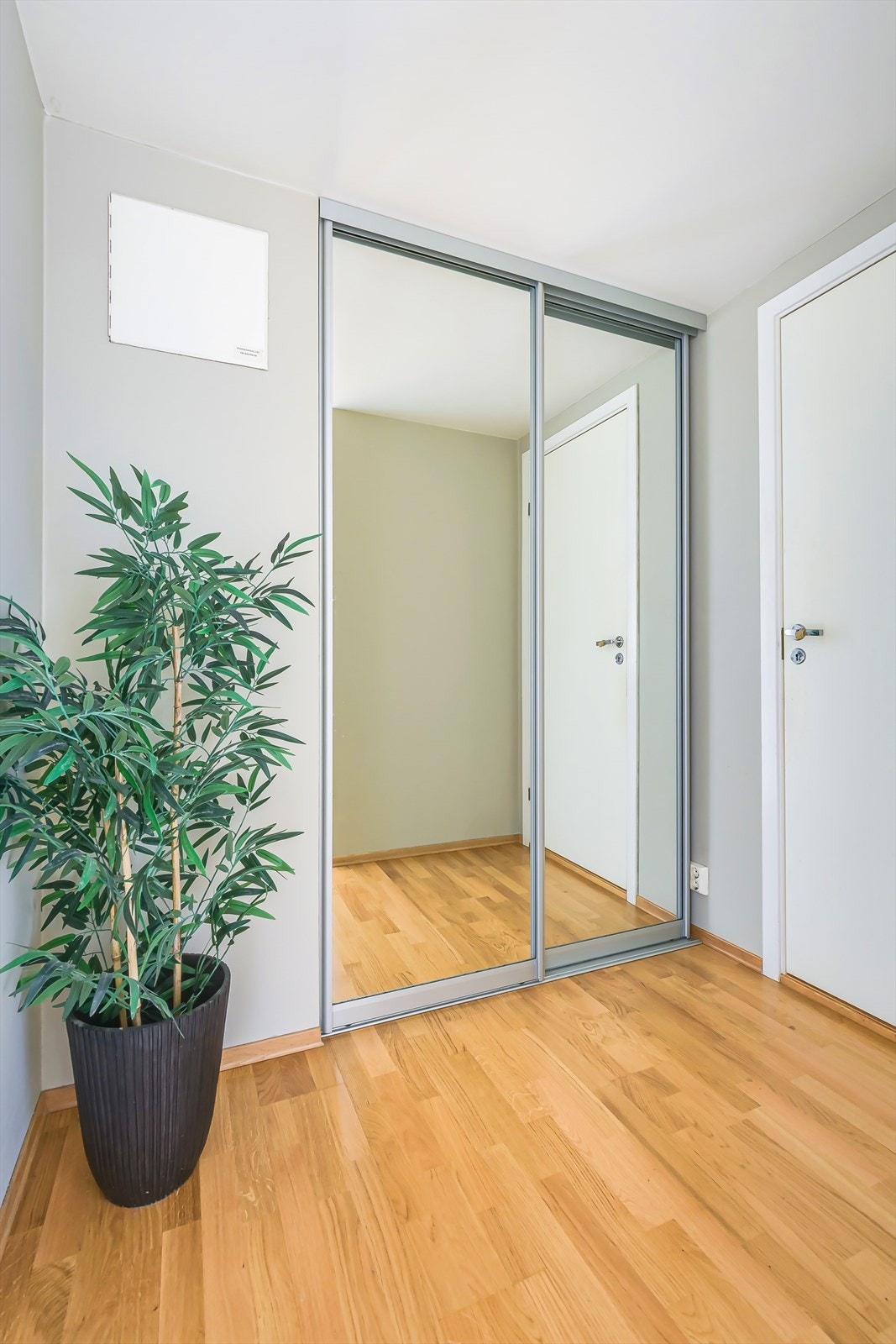 Videre inn i gangen er det montert en praktisk skyvedørsgarderobe med speilfronter. Galleribilde