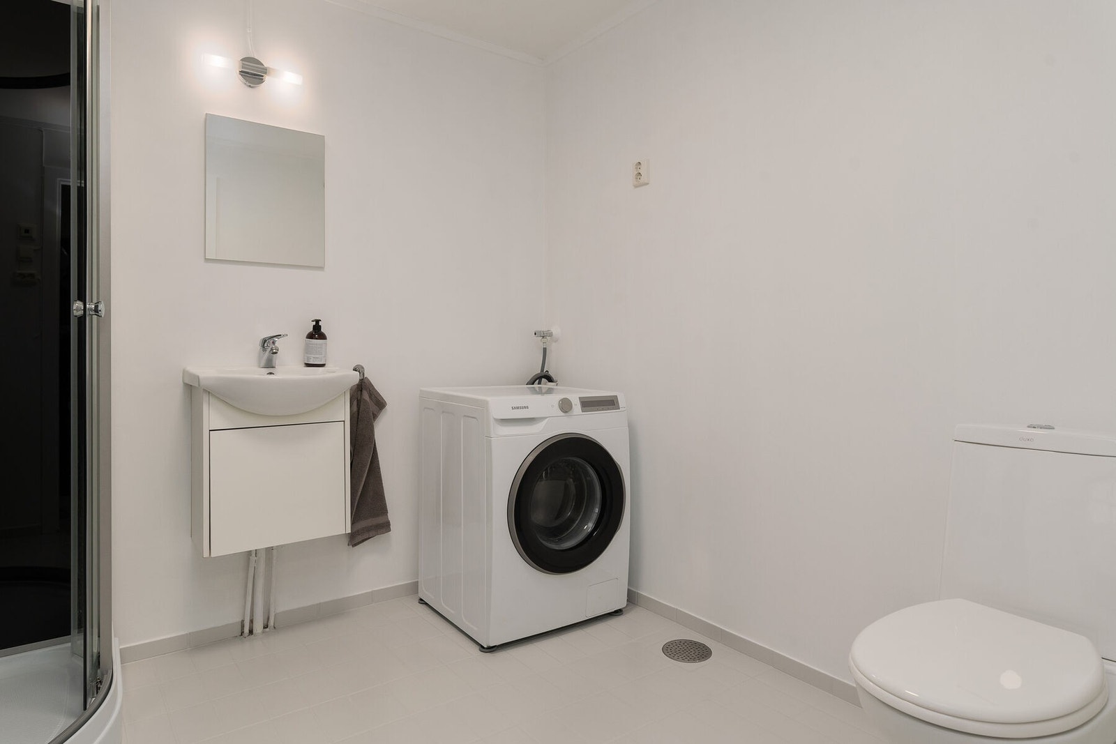 Badet har flislagt gulv med varmekabler, og malte plater på veggene. Rommet ble overflateoppusset i 2025. Galleribilde