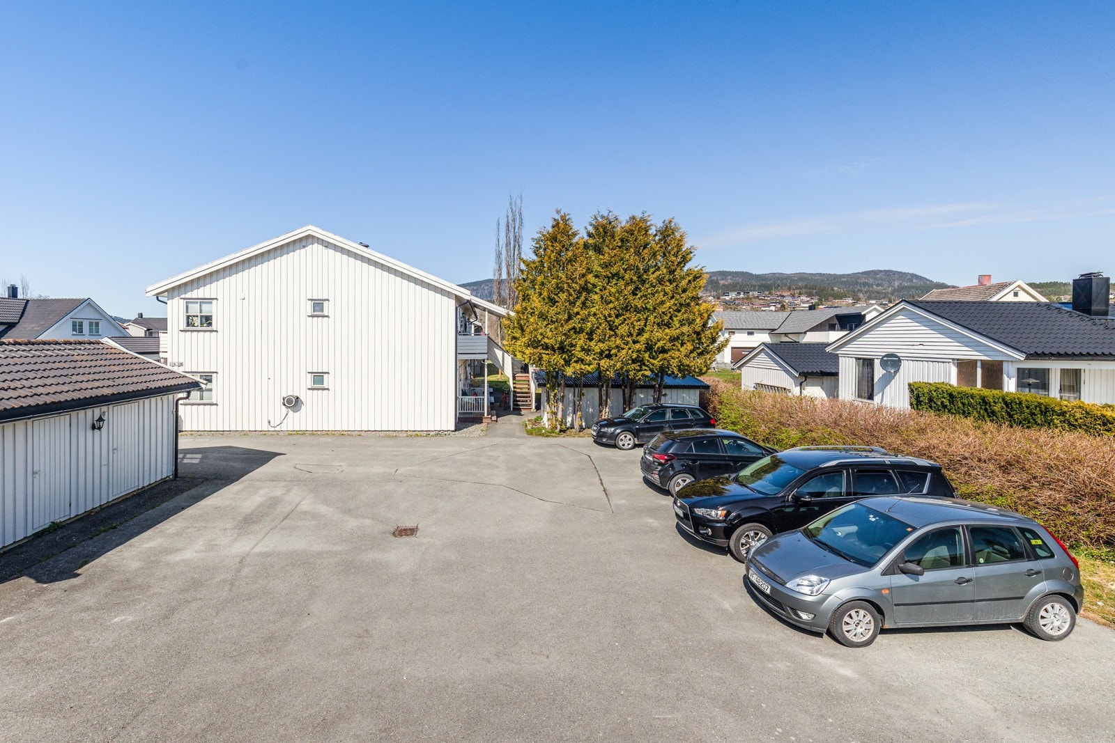 Det er flere biloppstillingsplasser på eiendommen. Leiligheten har egen p-plass. Galleribilde