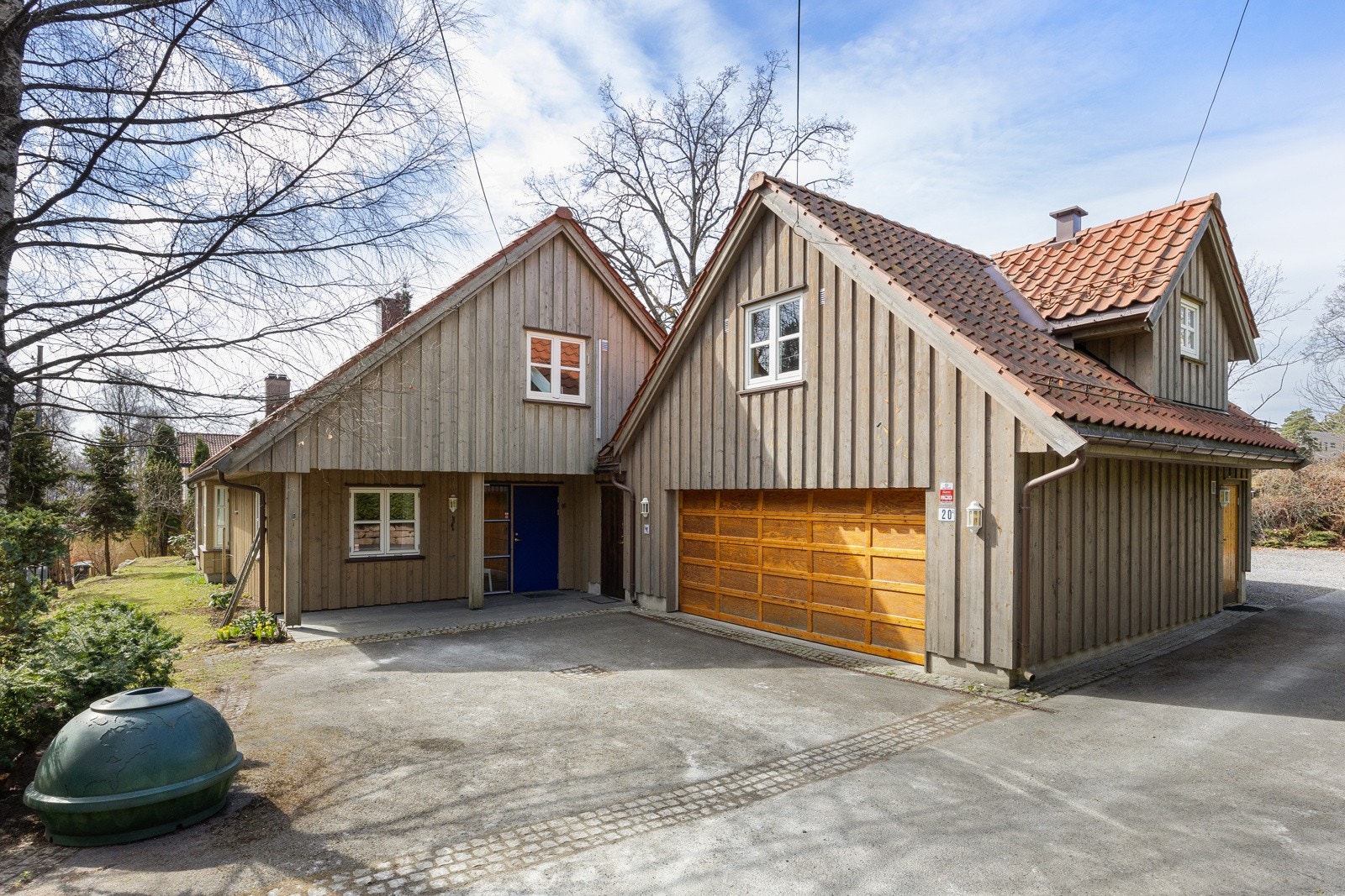 Mot nord har eiendommen asfaltert gårdsplass, overbygd inngang og en dobbelgarasje med hybel på loftet. Galleribilde