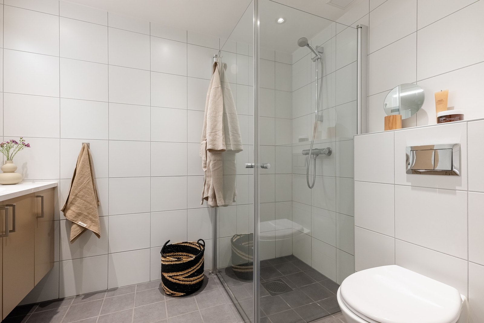 Videre er det vegghengt toalett og dusjhjørne med innfellbare dører i glass som frigjør plass på gulvet. Galleribilde