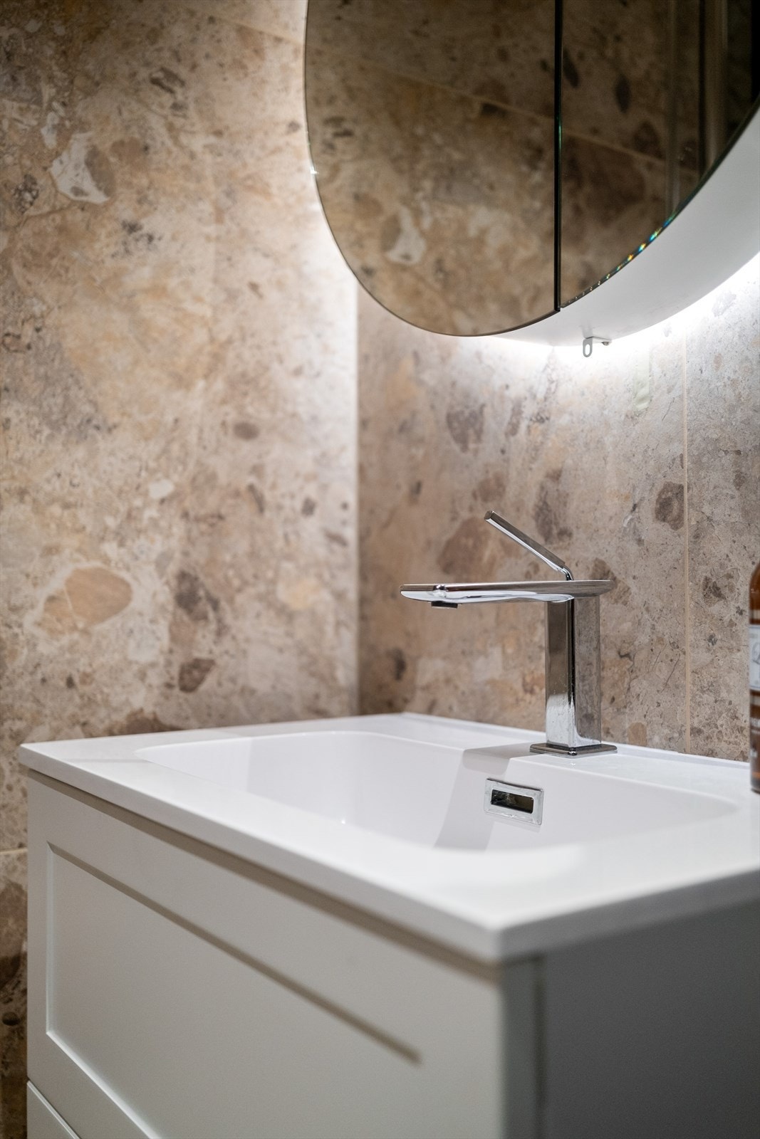 Baderommet er innredet med vegghengt klosett, servant med innredning, speilskap og dusjhjørne med svingbare glassdører. Galleribilde