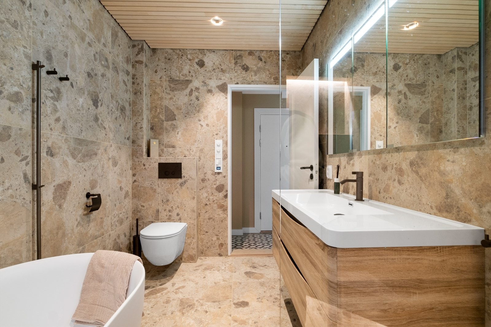 Tapwell i bronze, moderne fliskombinasjon og stilige spiler i tak som sikrer en lun atmosfære. Galleribilde