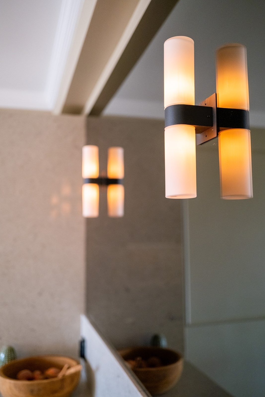 Detaljbilde av lekker belysning over sotet speil. Galleribilde