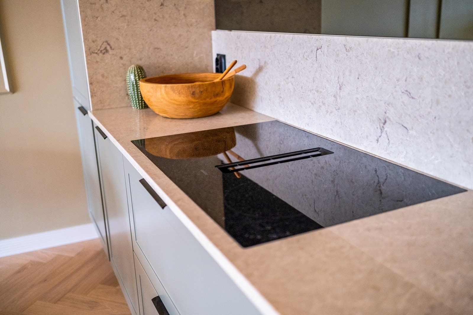 Kjøkkenet har rikelig med benk- og skapplass som sørger for en god arbeidssone. Planlimt platetopp med innfelt ventilator. Galleribilde