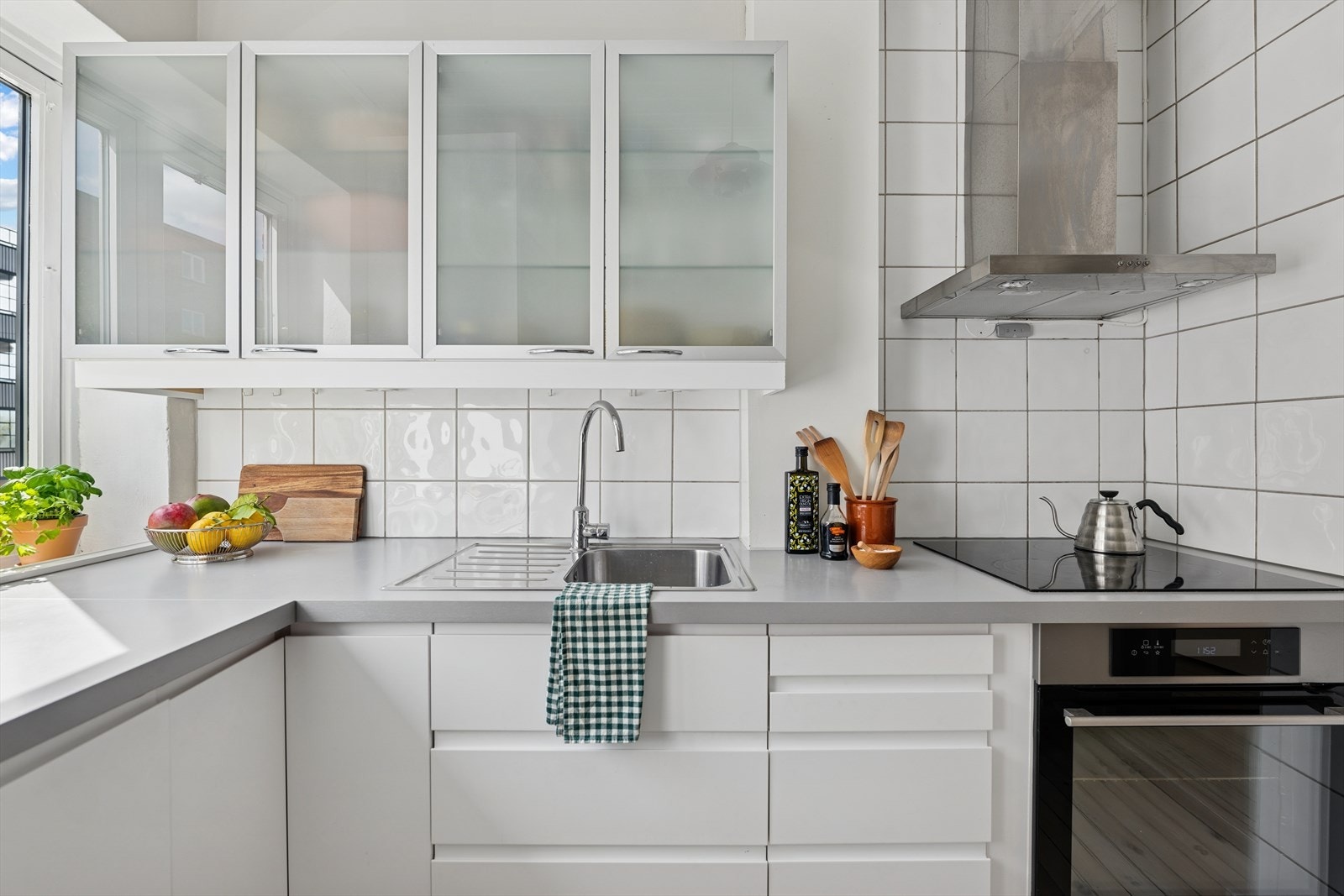 Kjøkkenet har rikelig med skap og benkeplass. Flislagte vegger under overskap sørger for at renholdet blir svært enkelt Galleribilde