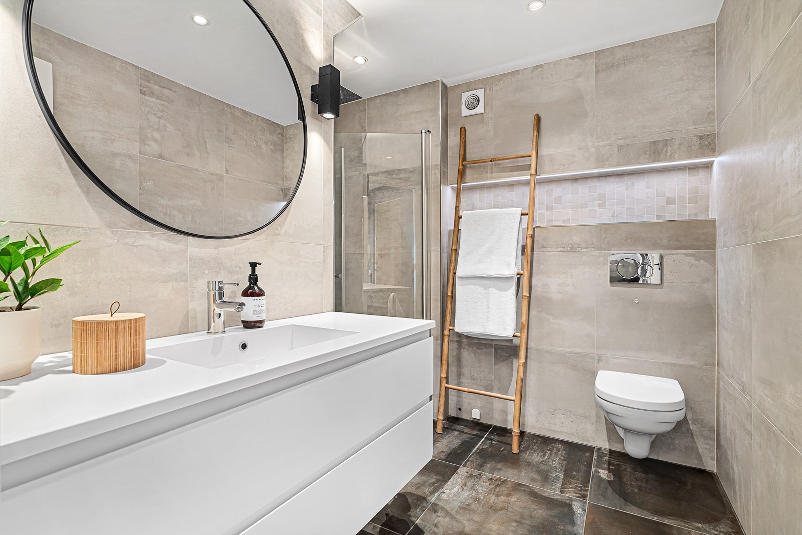 Badet ble i sin helhet pusset opp i 2019 hvor det er fliser med varmekabler på gulv, samt downlights i himling. Det inneholder en dusjnisje med innfellbare dusjdører, vegghengt toalett, samt badersominnredning med speil over. Galleribilde
