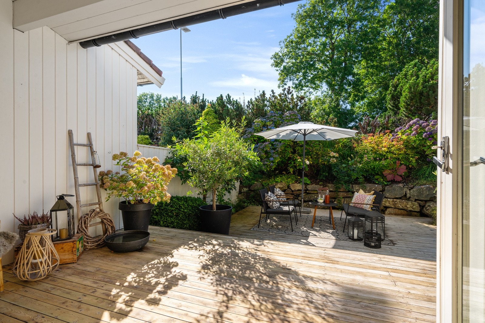 Skjermet og pent opparbeidet uteområde med både terrasse og bed. Galleribilde