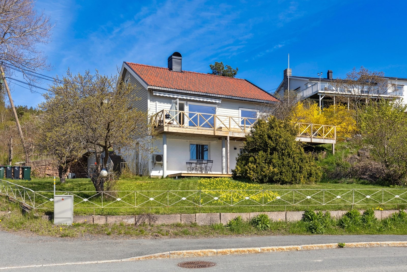 Pent opparbeidet tomt med gruset gårdsplass med innkjøring fra Utsikten. Gressplen og beplantninger rundt boligen. Noe naturtomt i nordre hjørne av tomten. Galleribilde