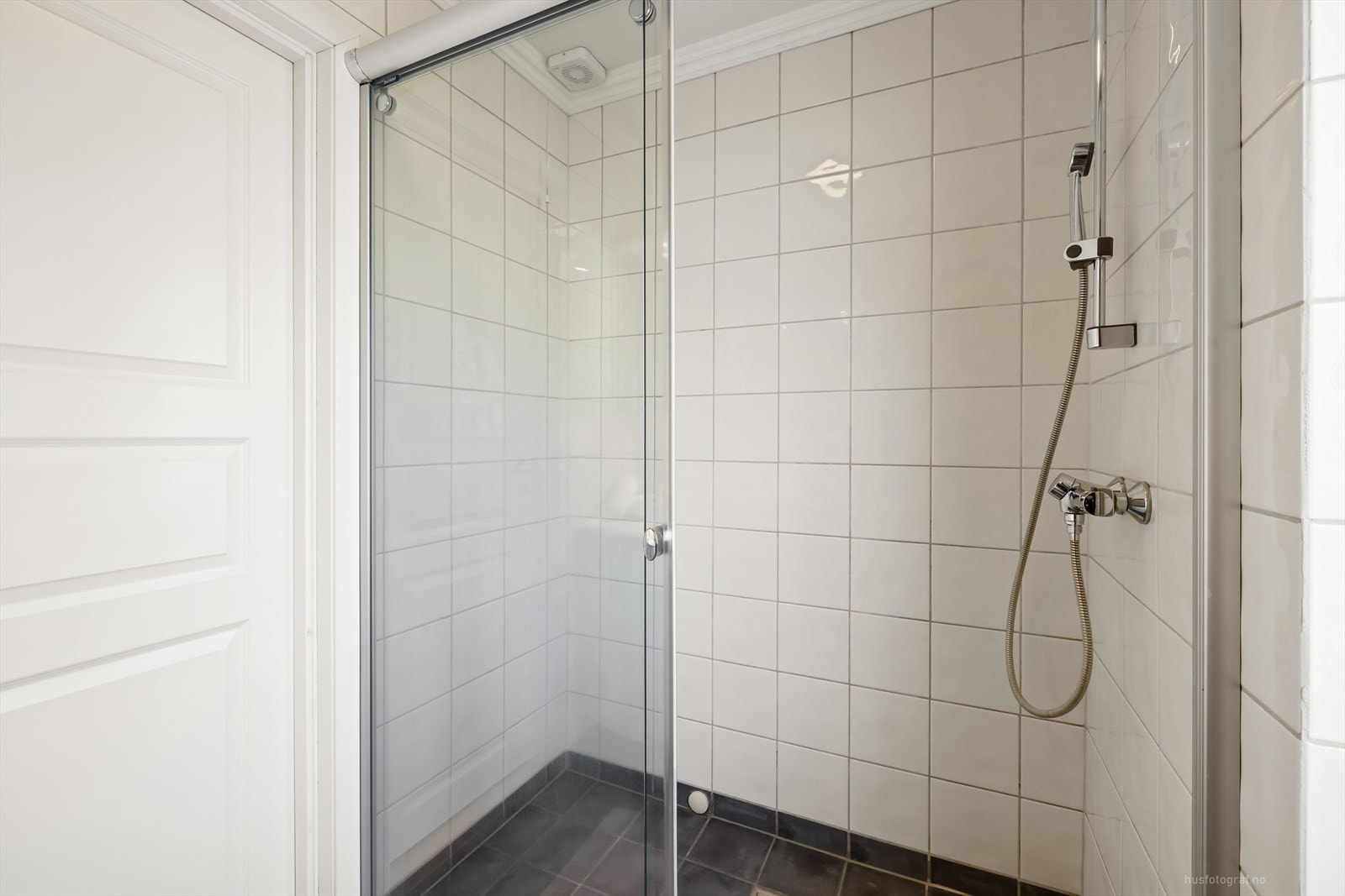Badet har dusjnisje og flislagte vegger og varmekabler i gulv Galleribilde