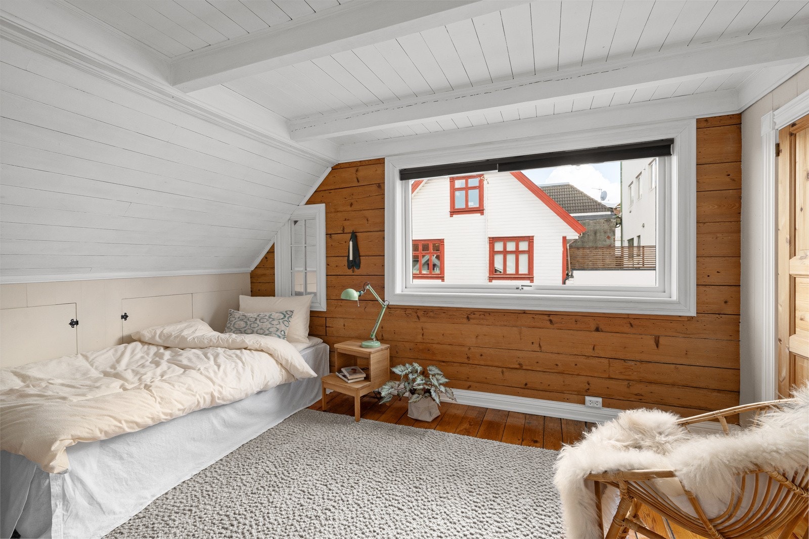 Sjarmerende soverom med utsikt mot byens tak og himmel. Galleribilde