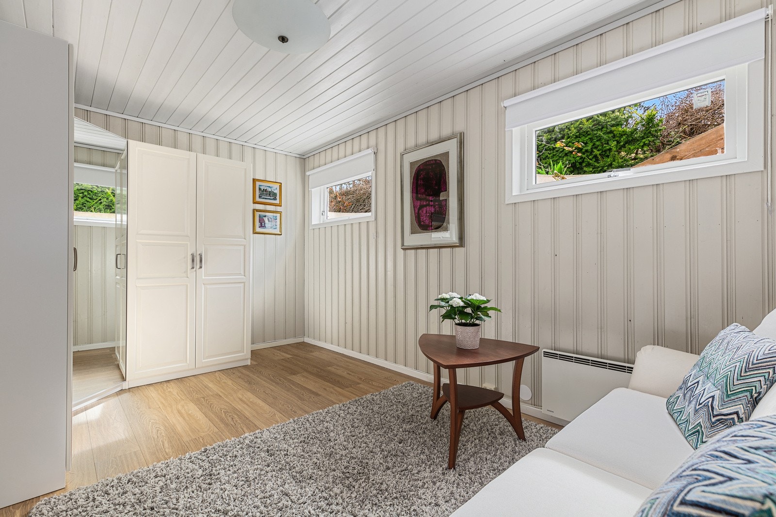 Kjellerstuen har inngang til et smakfullt allrom innredet med sofa og stor garderobe. Galleribilde