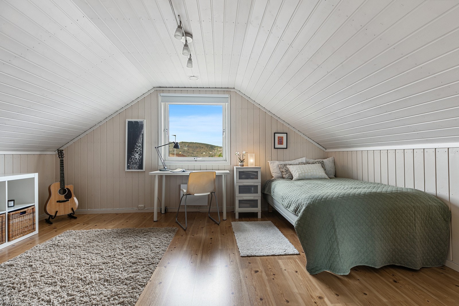 Det ene av soverommene i loftsetasjen er innredet med enkeltseng, skrivepult og oppbevaringsmøbel. Galleribilde