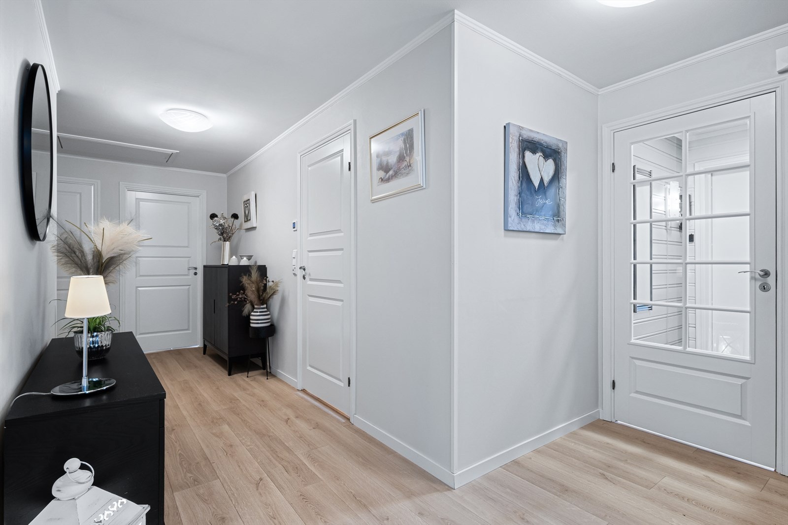 Stor hall på 14,5 m² med gulv av laminat og vegger bekledd med malt platekledning. Galleribilde