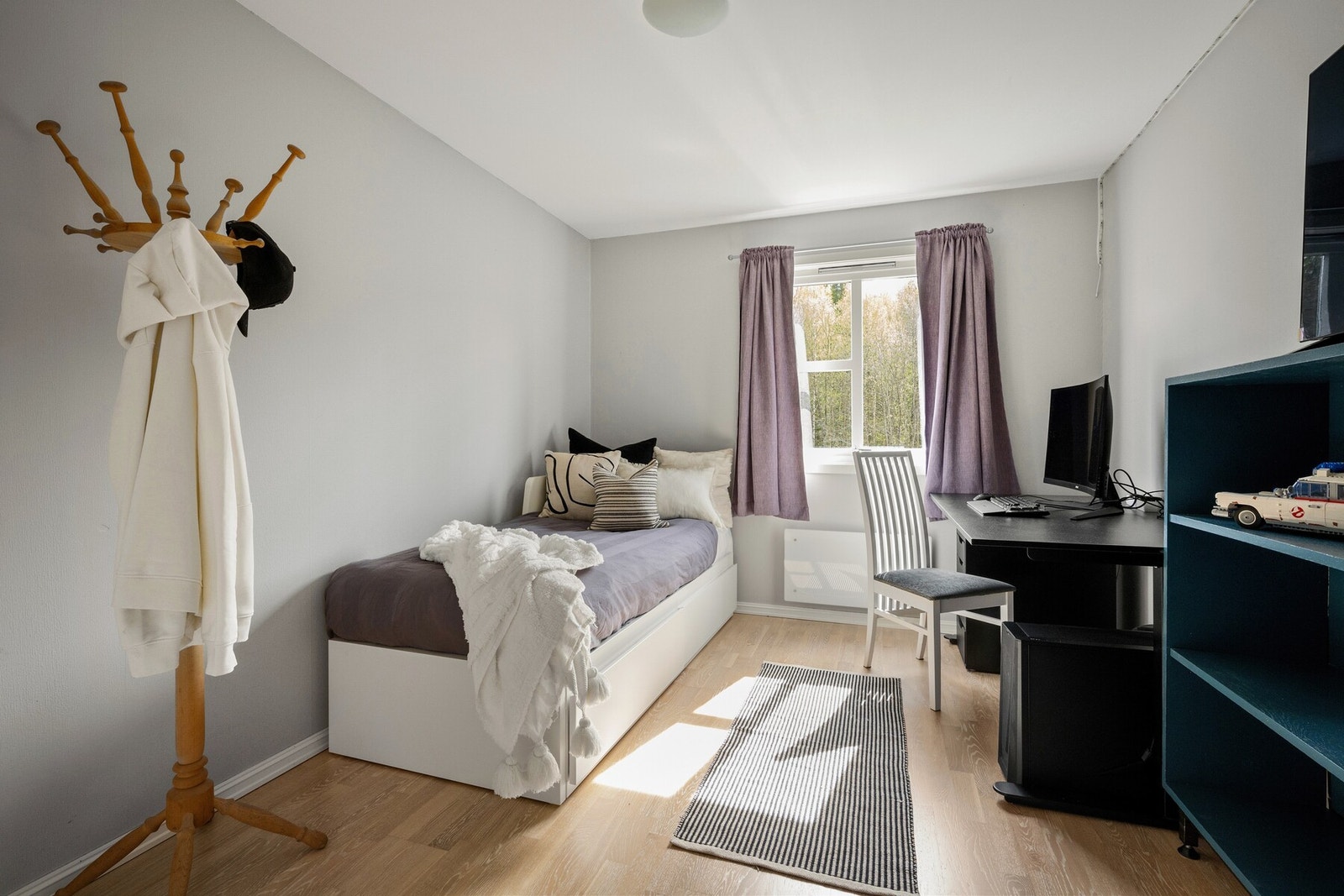 Rommet gir plass til dobbeltseng, nattbord og garderobeskap, samtidig som det oppleves åpent og behagelig. Galleribilde