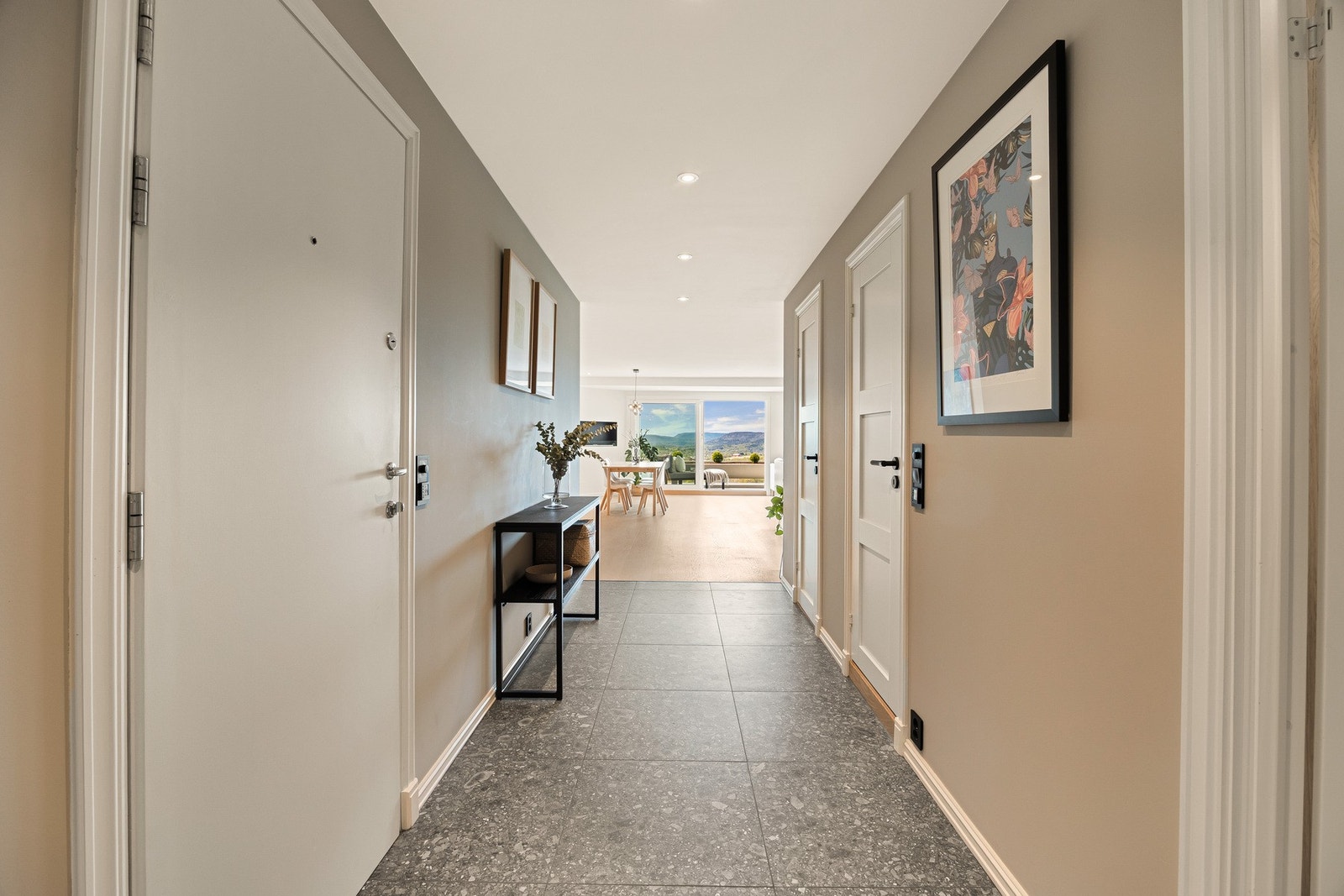 Velkommen inn til en lys og romslig entré som gir et åpent og innbydende førsteinntrykk. Gulvet er dekket med store fliser og har behagelige varmekabler for ekstra komfort. Galleribilde