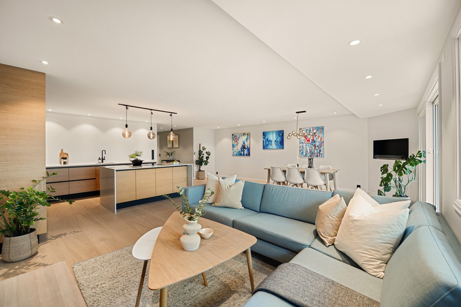 Åpen stue- og kjøkkenløsning med kjøkkenøy som skaper en naturlig og praktisk rominndeling. Galleribilde