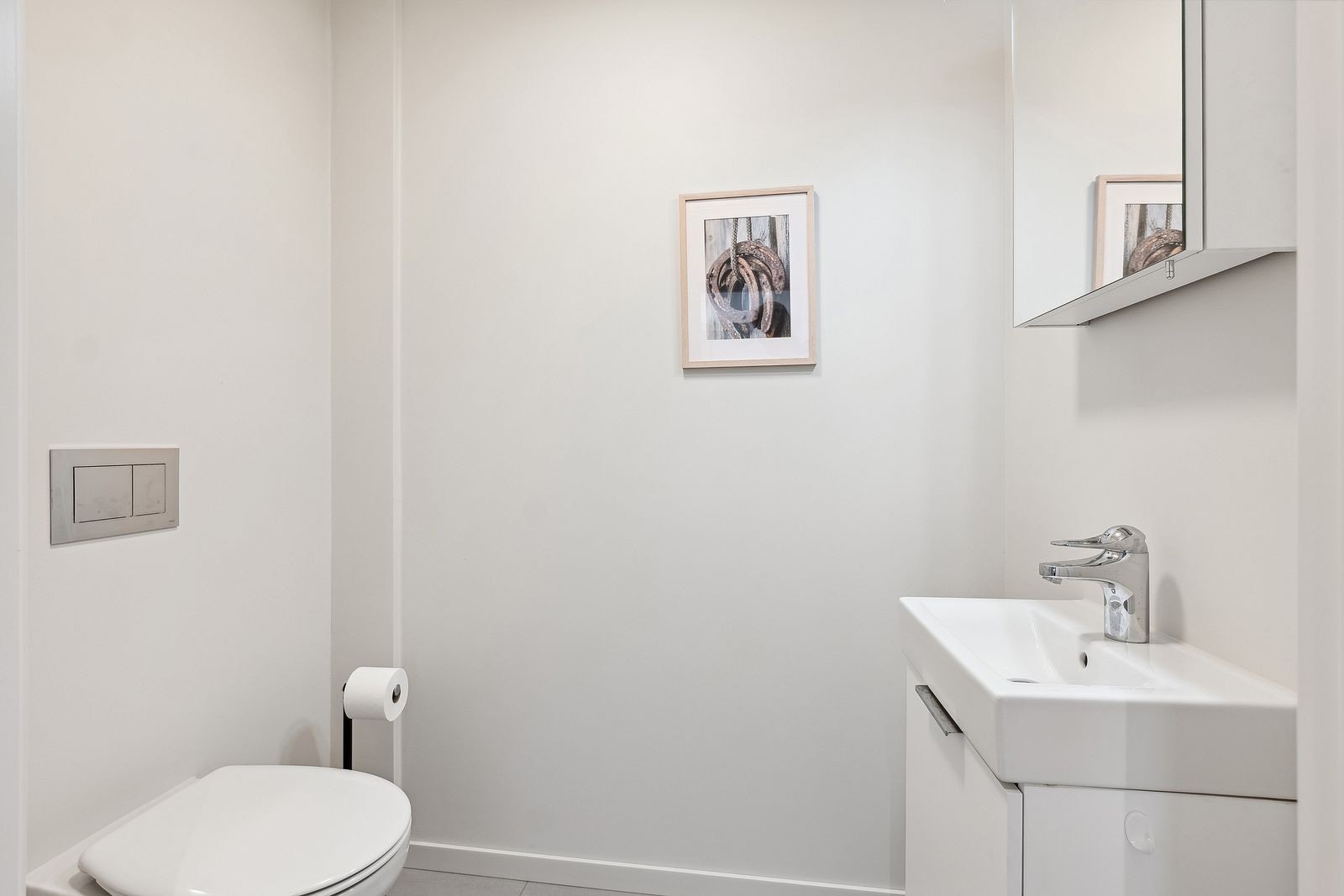 Seperat WC med vegghengt toalett og servant m/innredning. Galleribilde