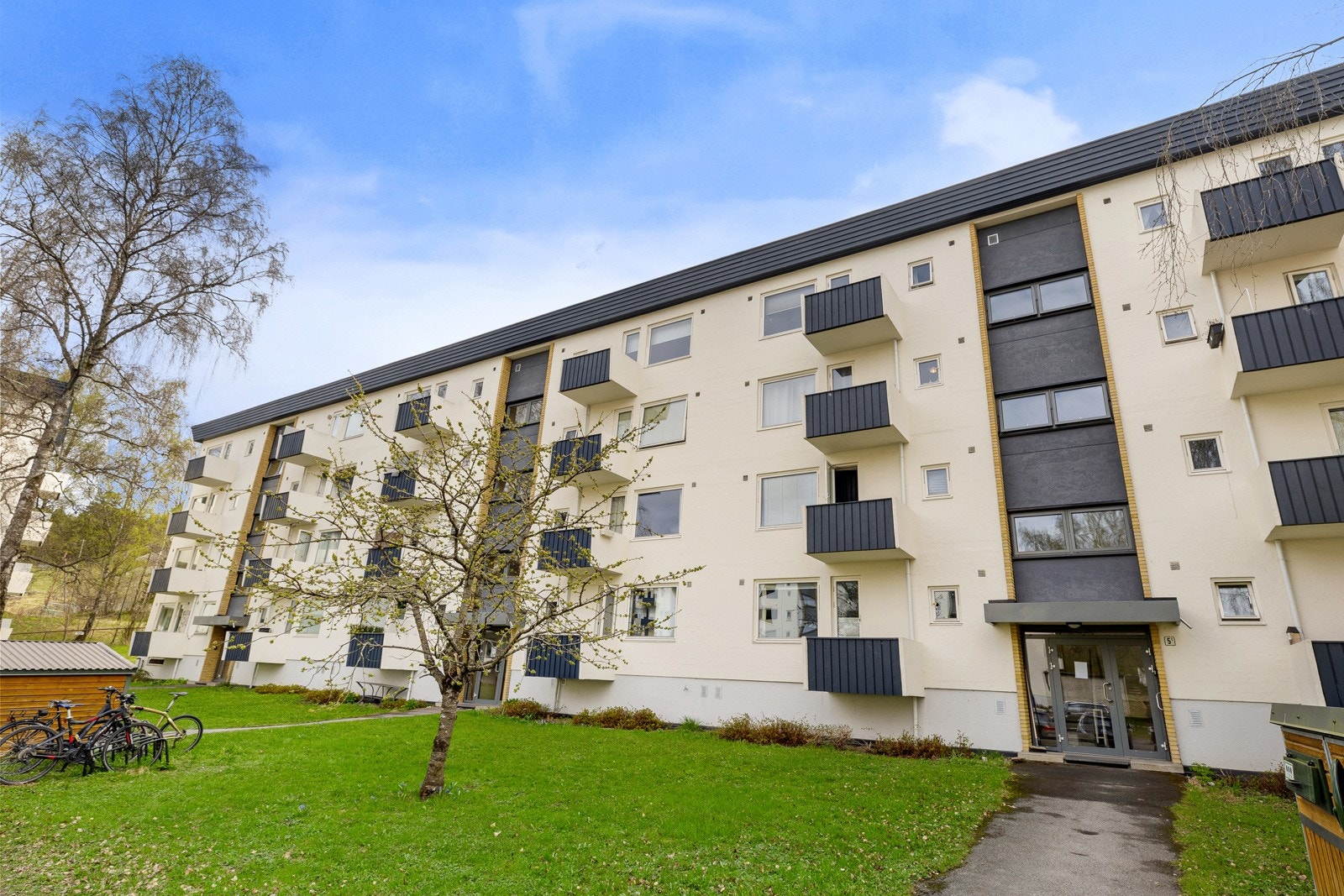 Ryddige og velstelte fellesareal med grøntanlegg beplantet med busker og trær, samt asfaltert blindvei, fortau og adkomst til bebyggelsen. Galleribilde