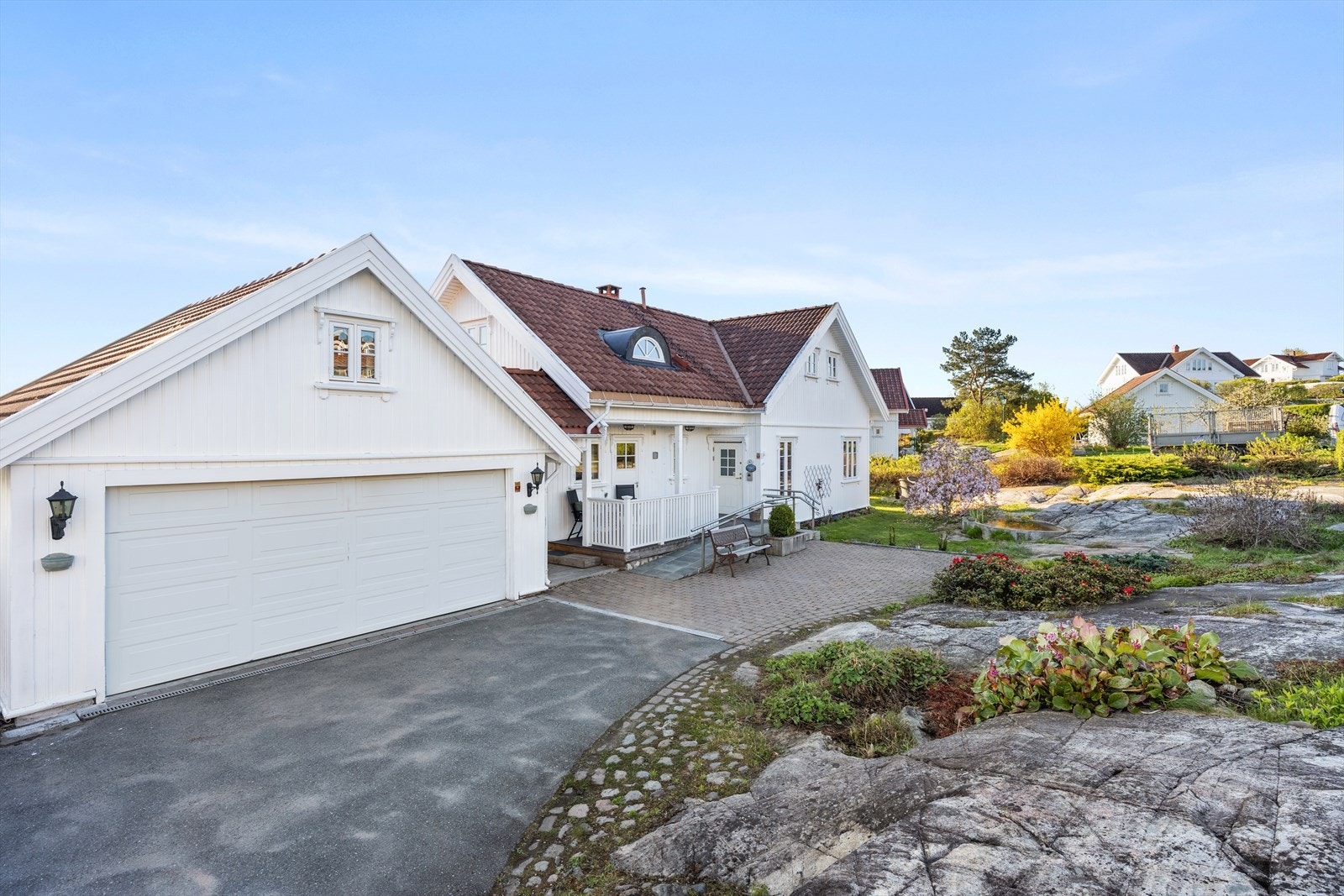 Eiendommen har en ryddig og pent opparbeidet adkomst med asfaltert innkjørsel kombinert med belegningsstein og beplantning. Galleribilde