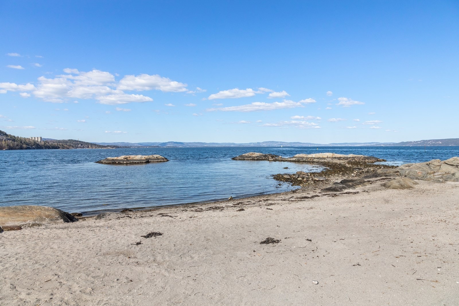 Ellefstranda ligger ytterst på Nærsnestangen med kveldssol, sandstrand, stupebrett og en liten gresslette for lek og soling. Galleribilde