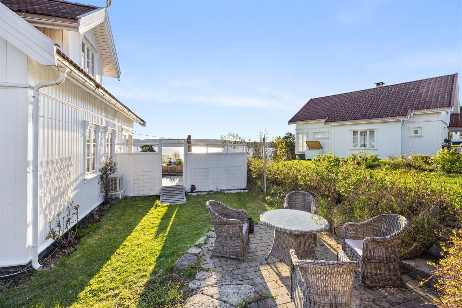 Stor og pent opparbeidet tomt med gressplener, markterrasser og beplantning. Galleribilde