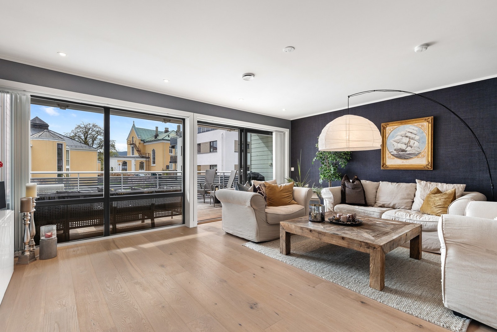 Romslig stue med 1-stavs parkettgulv og downlights i tak Galleribilde