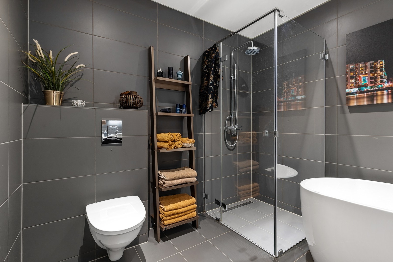 Badet består av badekar, dusjhjørne, vegghengt klosett og servant med underskap Galleribilde