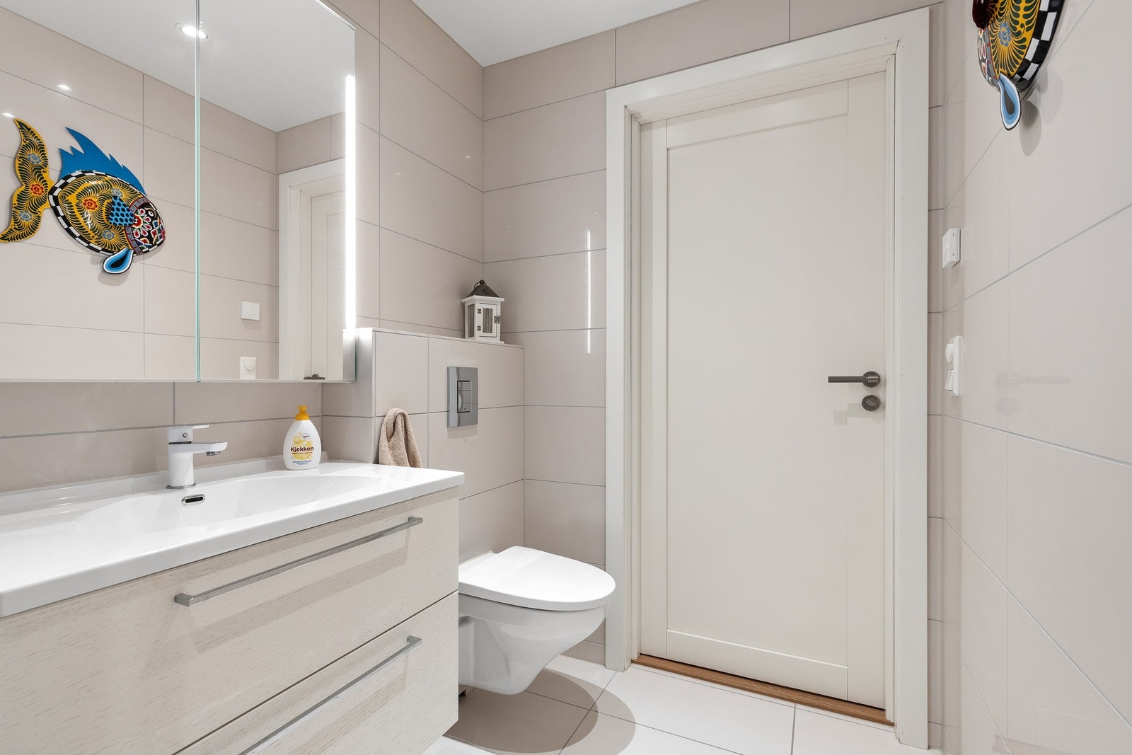 Badet består av vegghengt klosett, servant med underskap, speil med LED lys og dusjhjørne Galleribilde