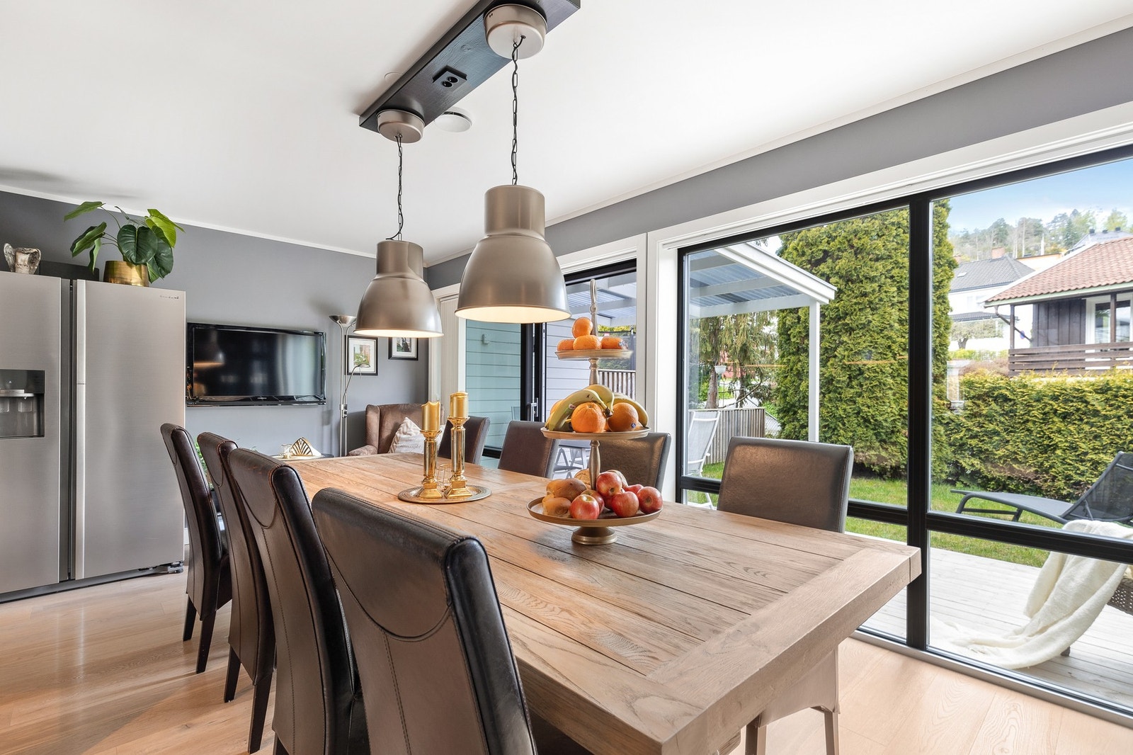 Skyvedører mot skjermet uteplass, som blir en forlengelse av stuen på sommerstid Galleribilde