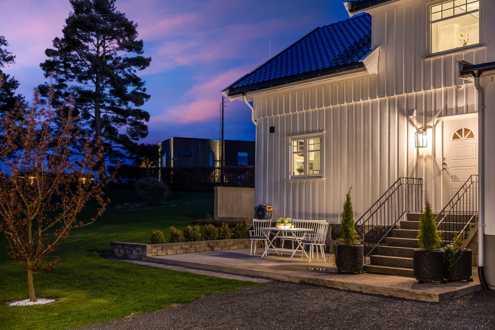 Terasseplatting ved boligens inngangsparti i kveldsstemning. Galleribilde