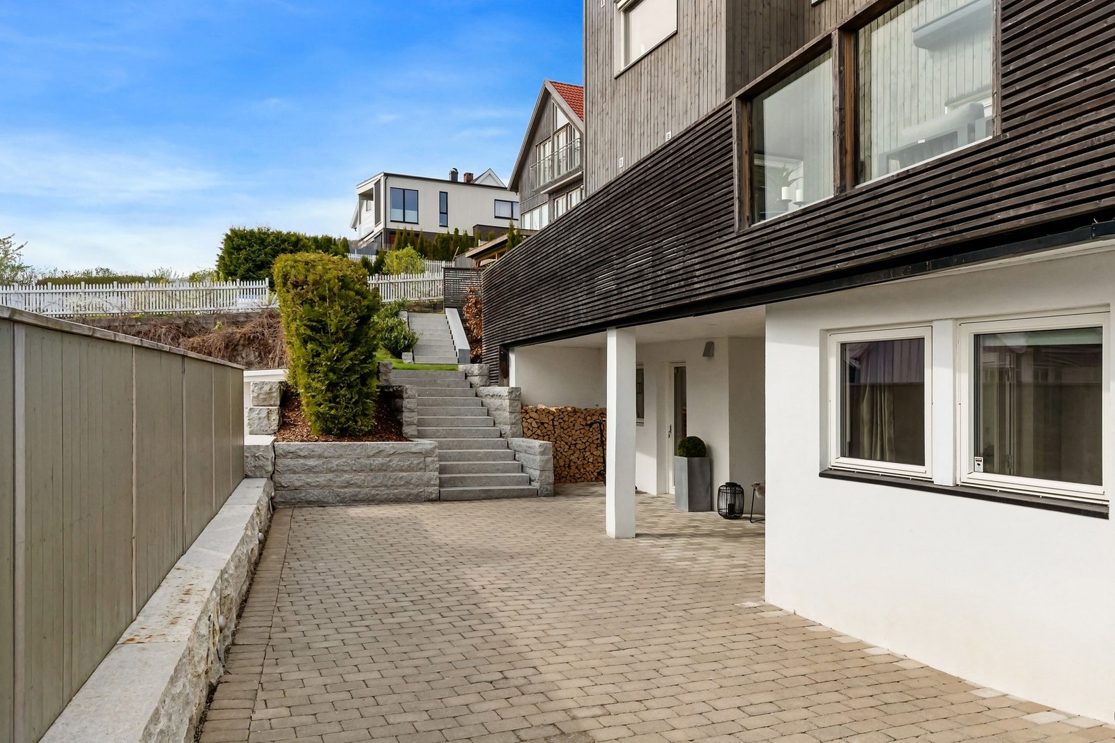 Pent opparbeidet steinbelagt gårdsplass med biloppstillingsplass. Galleribilde