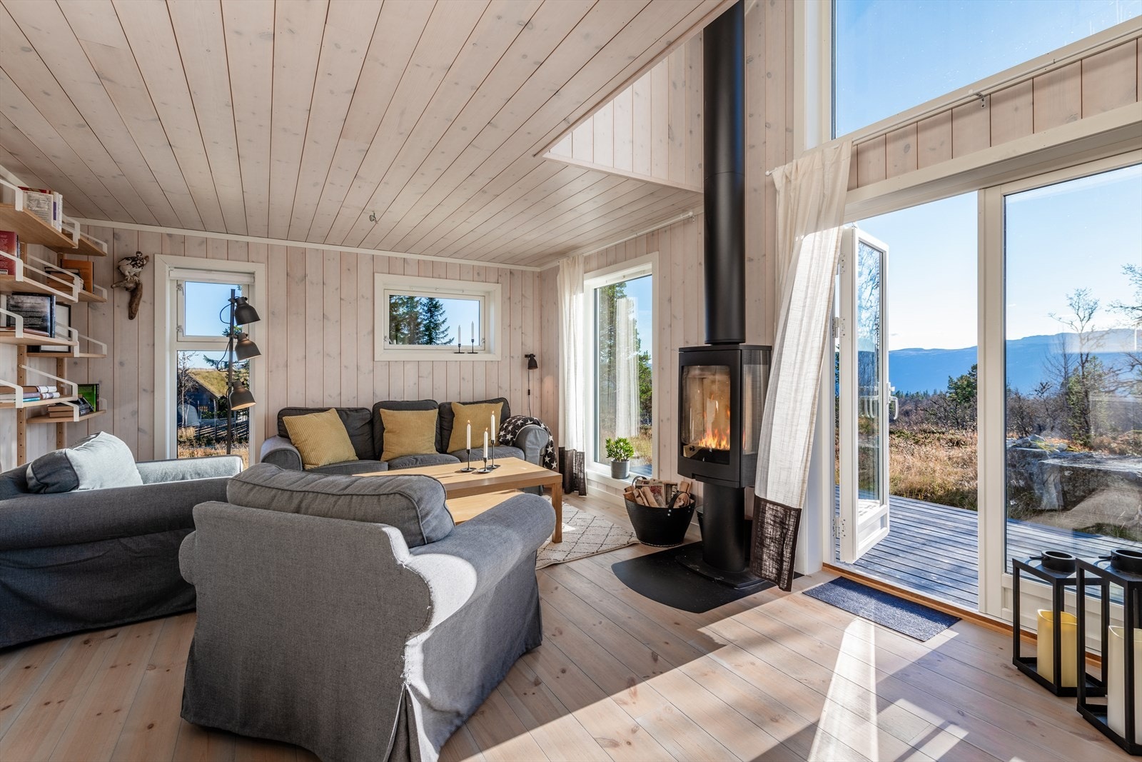 Stor romslig stue/spisestue/kjøkken med utgang til platting på fremsiden av hytta Galleribilde