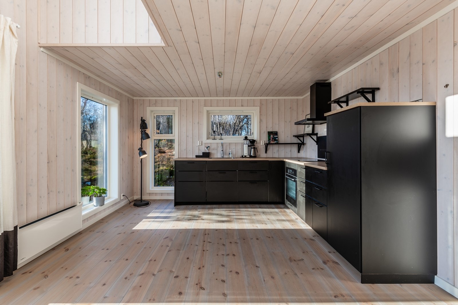 Kjøkkenet har innredning med glatte fronter. Benkeplaten er av laminat. Det er integrert kjøleskap, oppvaskmaskin, platetopp og stekeovn Galleribilde