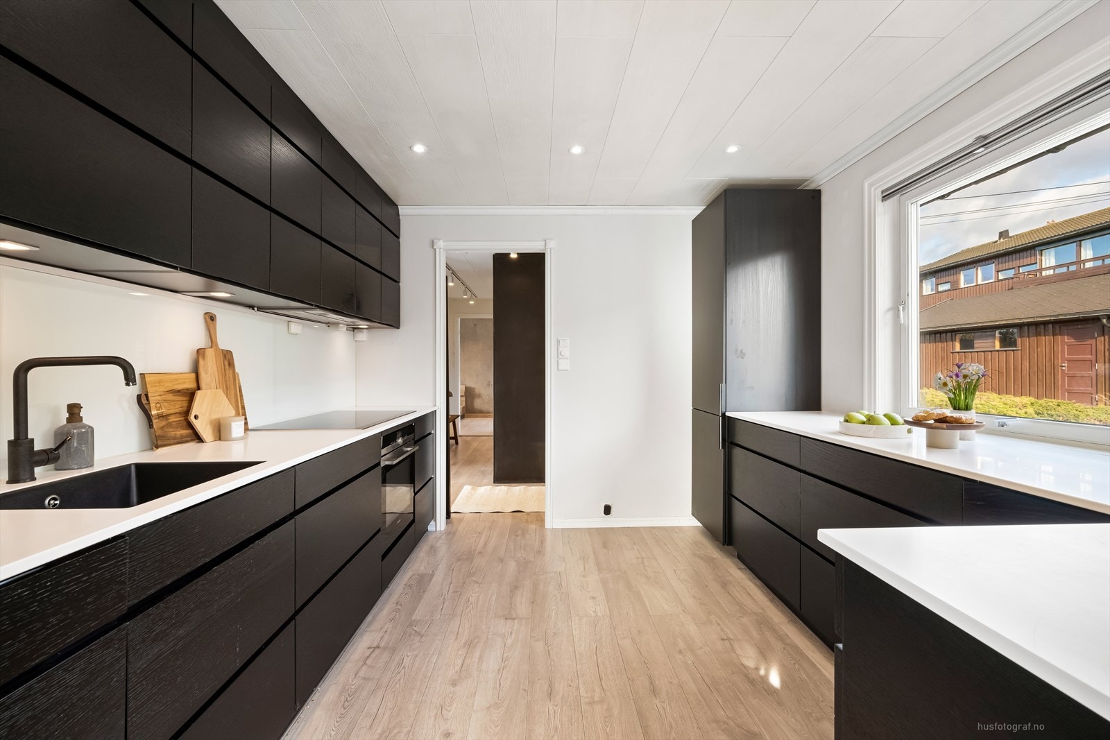 Kjøkkenet fremstår som moderne og pent, med mørke, slette fronter og integrerte hvitevarer. Galleribilde