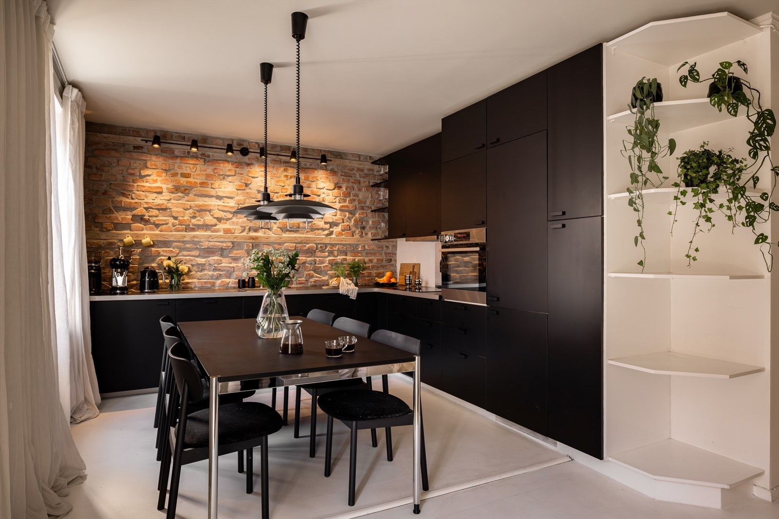 Kjøkkenet er et virkelig godt rom i leiligheten og perfekt for deg som liker å lage mat! Sorte fronter (byttet i 2023) står i kontrast til den røffe teglsteinsveggen over benkeplaten, og gir kjøkkenet et trendy uttrykk. Galleribilde