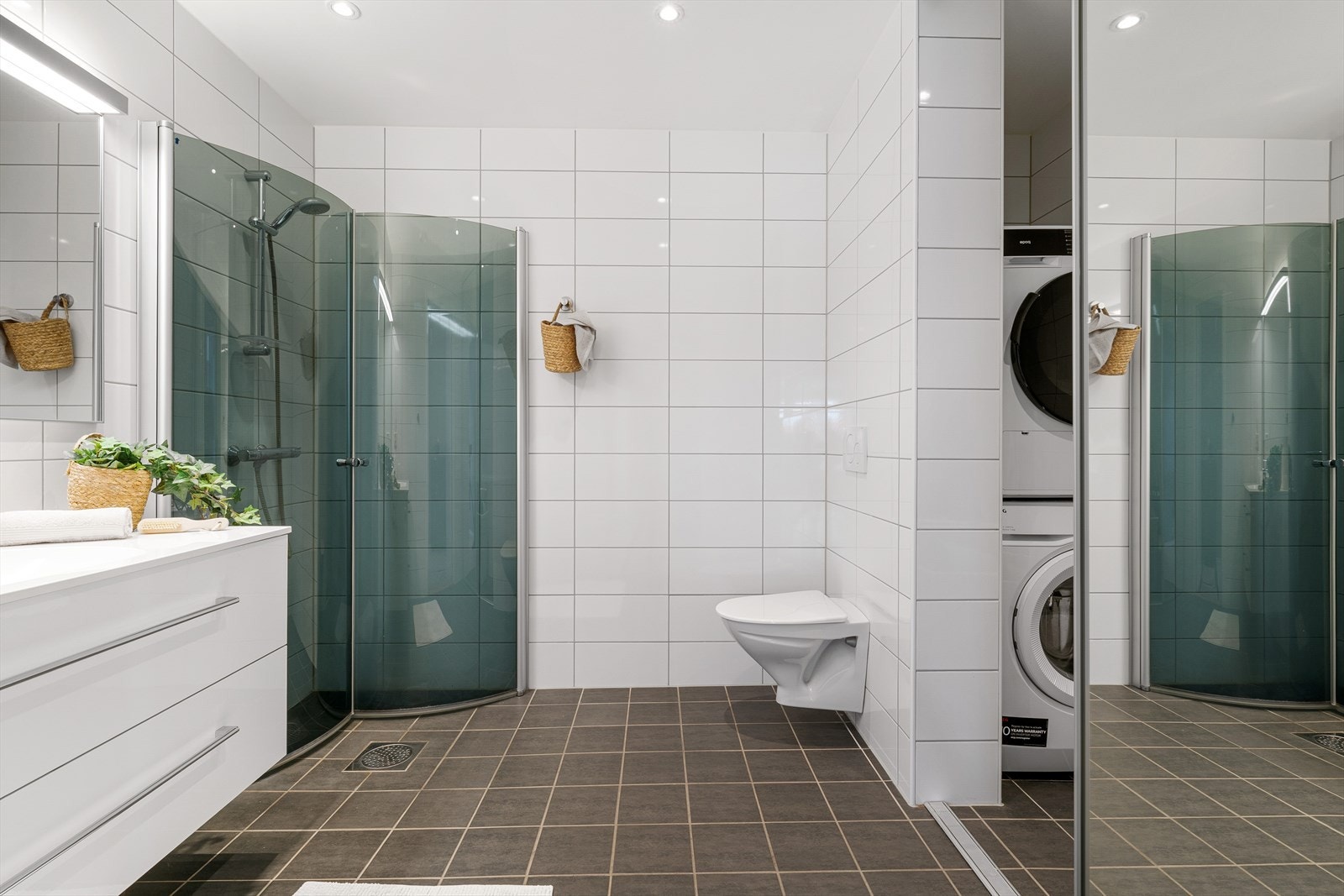 - Badet er innredet med vegghengt toalett, servant, dusj med innfellbare dusjdører og speil med integrert belysning - Galleribilde