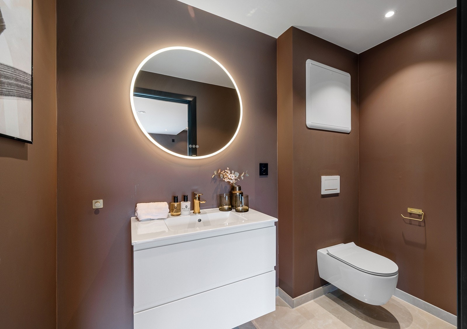 Wc-rom med flislagt gulv og malte glatte veggflater. Innredningen består av vegghengt vannklosett, underskap med servant, speil og lys. Gulvvarme og downlights i himling. Galleribilde
