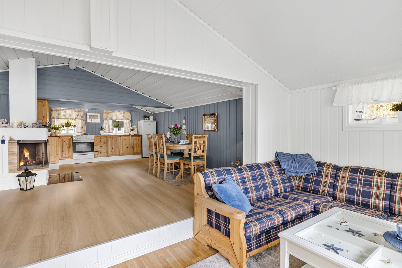 Lunt og hjemmekoselig hyttepreg med overflater av trepanel og malte plater Galleribilde