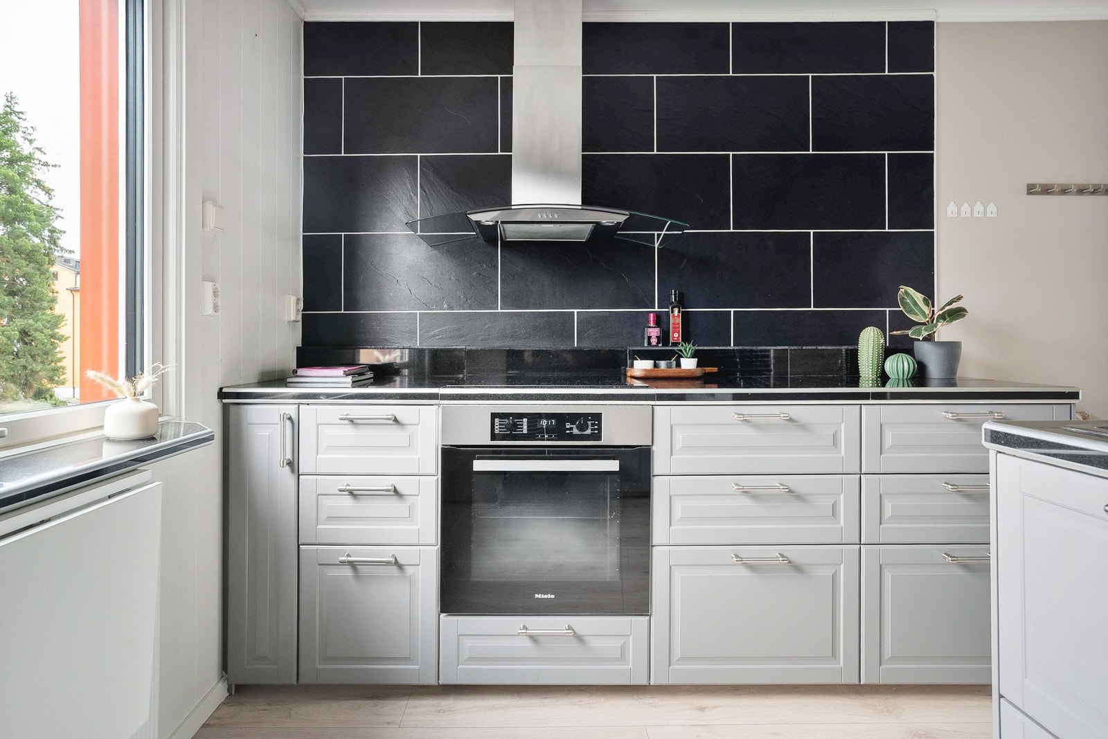 Stilren kjøkkeninnredning opplyst å være fra 2013 med profilerte fronter. Galleribilde