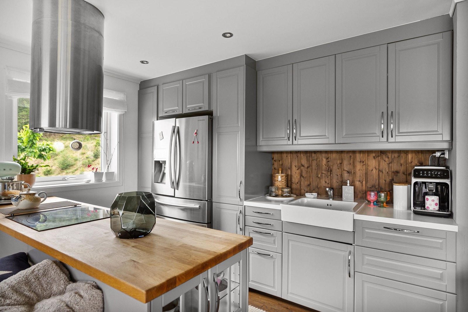 Kjøkkeninnredning med masse skap- og benkeplass. Stort dobbelt kjøleskap med kullsurevann og isbitter Galleribilde