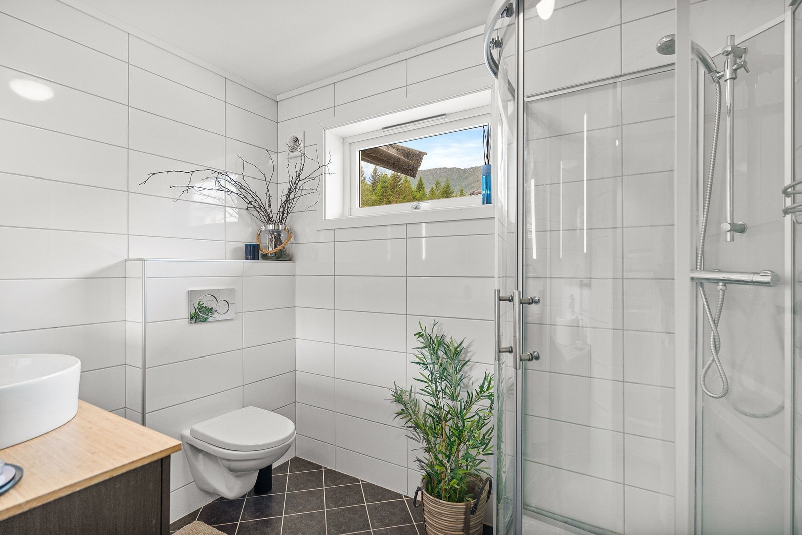 Helfliset bad med vegghengt toalett, dusjkabinett og innredning Galleribilde