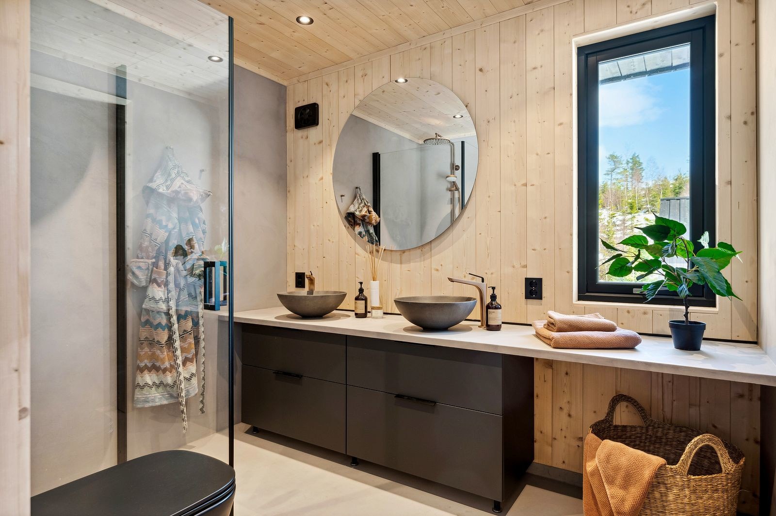 Videre har badet et vegghengt toalett og separat dusjhjørne med innfellbare glassdører. Dimbare LED downlights i himling. Galleribilde