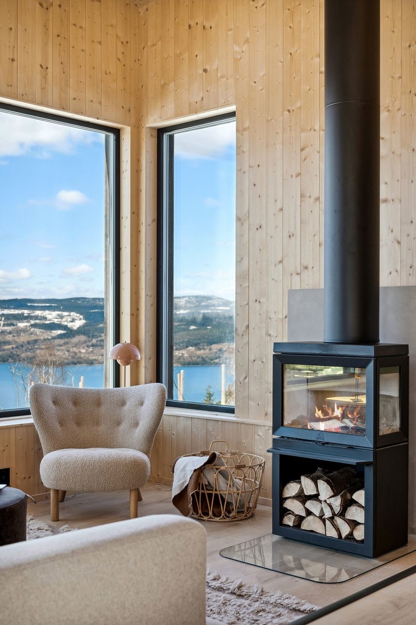 Midt i rommet er det en moderne peisovn, som gir en god atmosfære, varme og hygge. Galleribilde