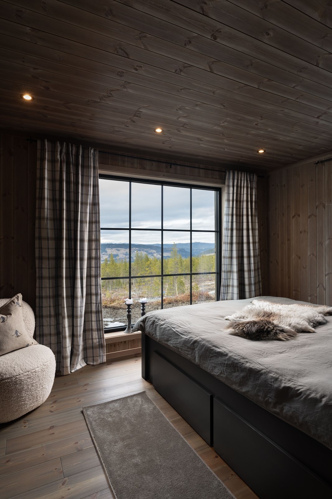 Det er tre soverom i hovedetasjen. Her fra hovedsoverommet med store vinduer som rammer inn den flotte utsikten. Galleribilde