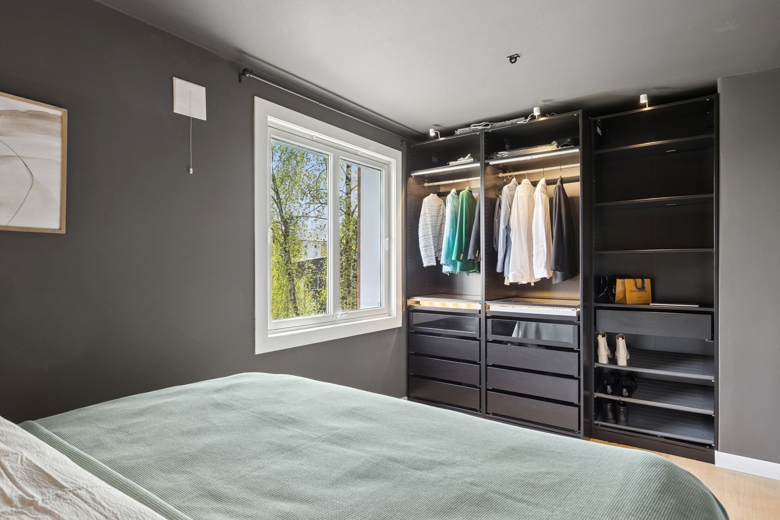 Rommet har også en praktisk garderobeløsning og et stort vindu som inviterer lyset og naturen inn og som gir rommet en hyggelig atmosfære. Galleribilde