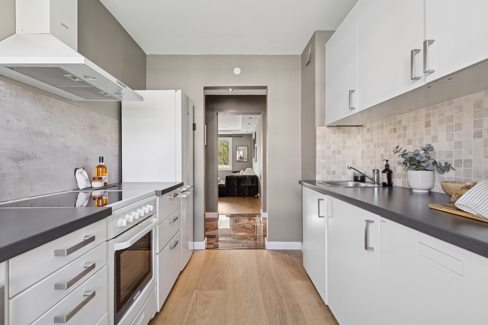 Kjøkkenet er utstyrt med innredning med hvite glatte fronter og en slitesterk benkeplate av laminat. Det er opplegg for oppvaskmaskin, noe som gjør hverdagen enklere. Galleribilde